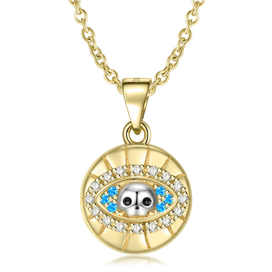 Gold necklace with an eye-shaped pendant featuring blue stones and clear stones on a white background