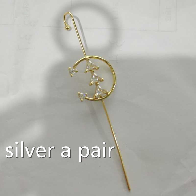 Gold earring with a crescent moon design on a light gray background