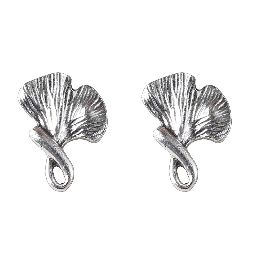 Pair of silver leaf-shaped earrings on a white background