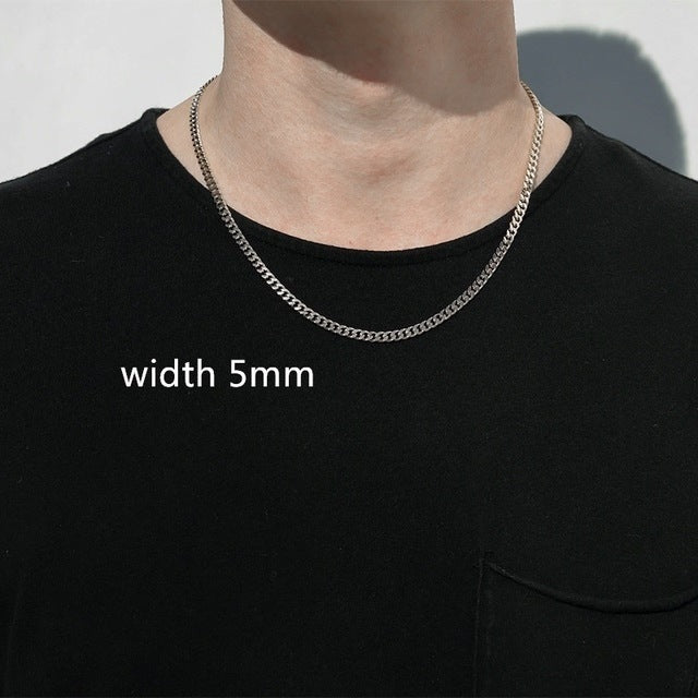 Silver chain necklace worn by a person on a black shirt with 'width 5mm' text.