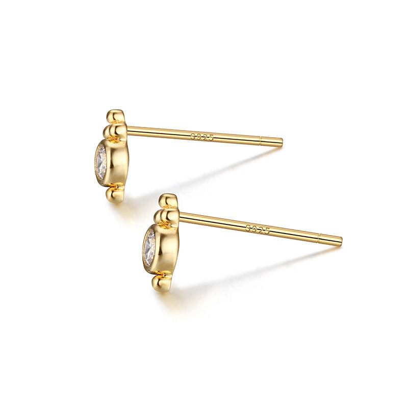 Gold earrings with gemstones on a white background
