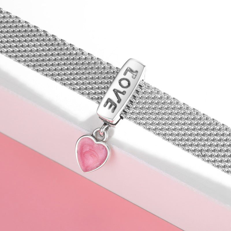Silver bracelet with a heart-shaped charm and 'LOVE' inscription on a pink background