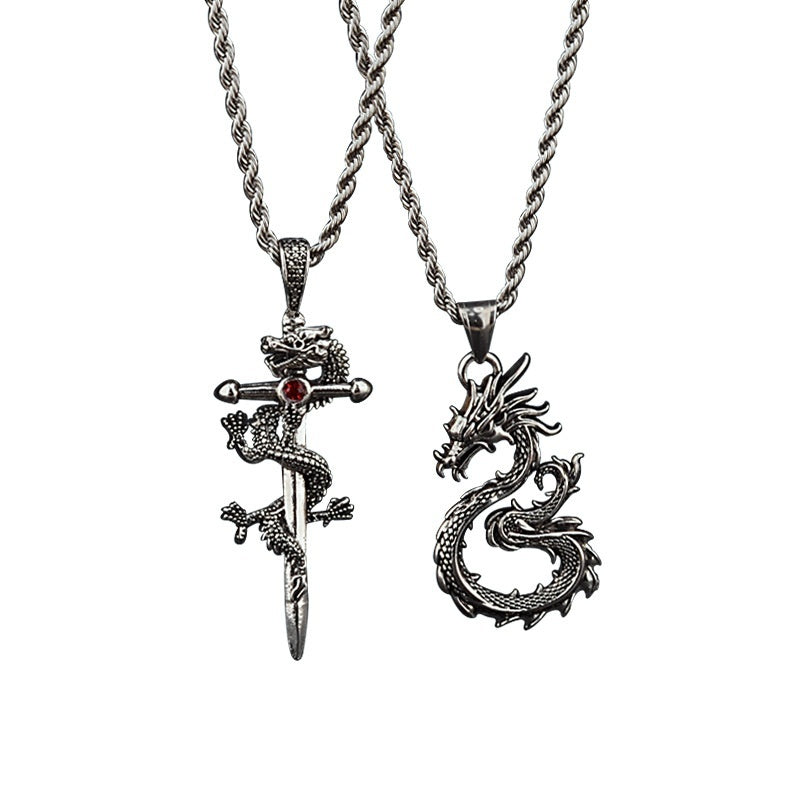 Two dragon-themed pendants on chains against a white background