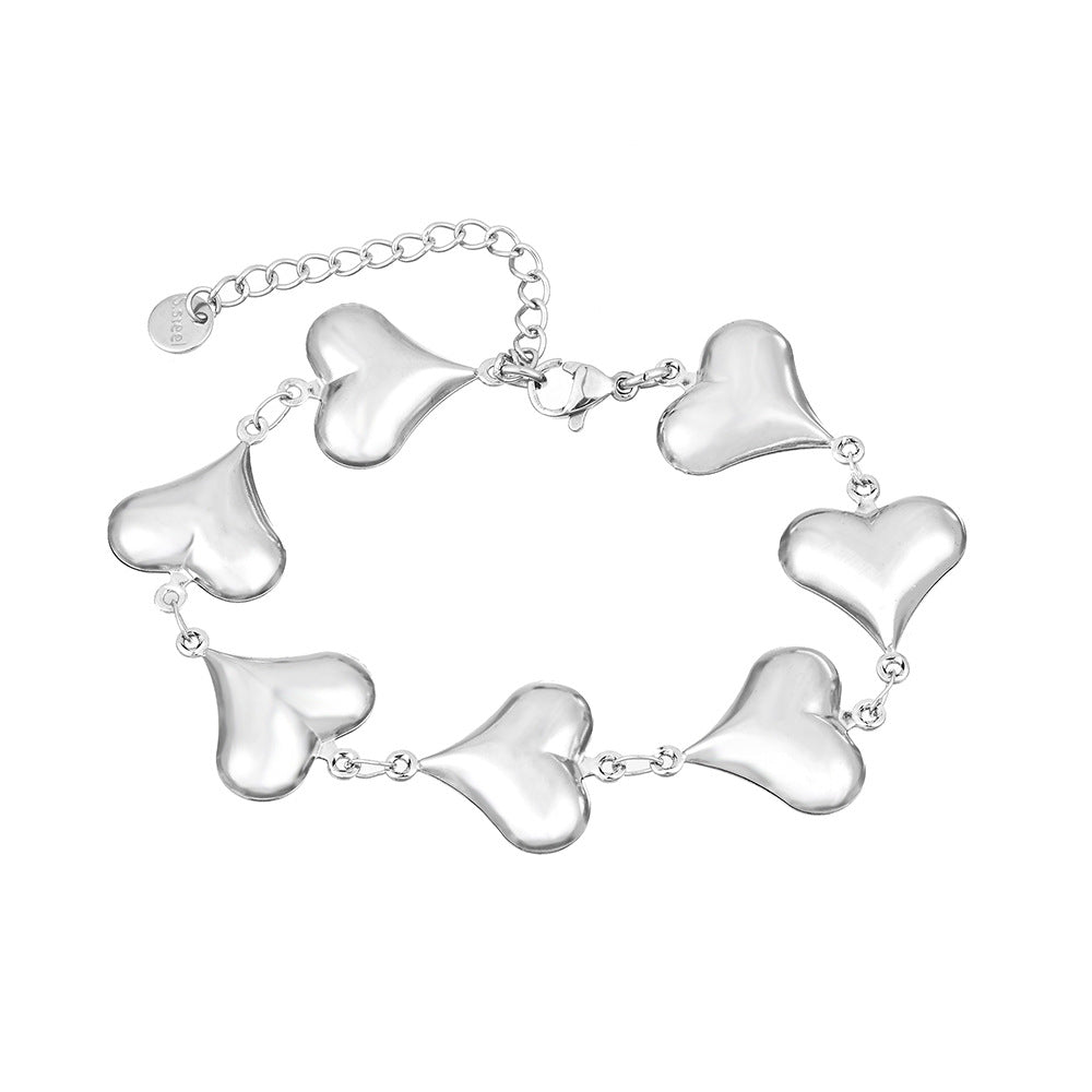 Silver bracelet with heart-shaped links on a white background