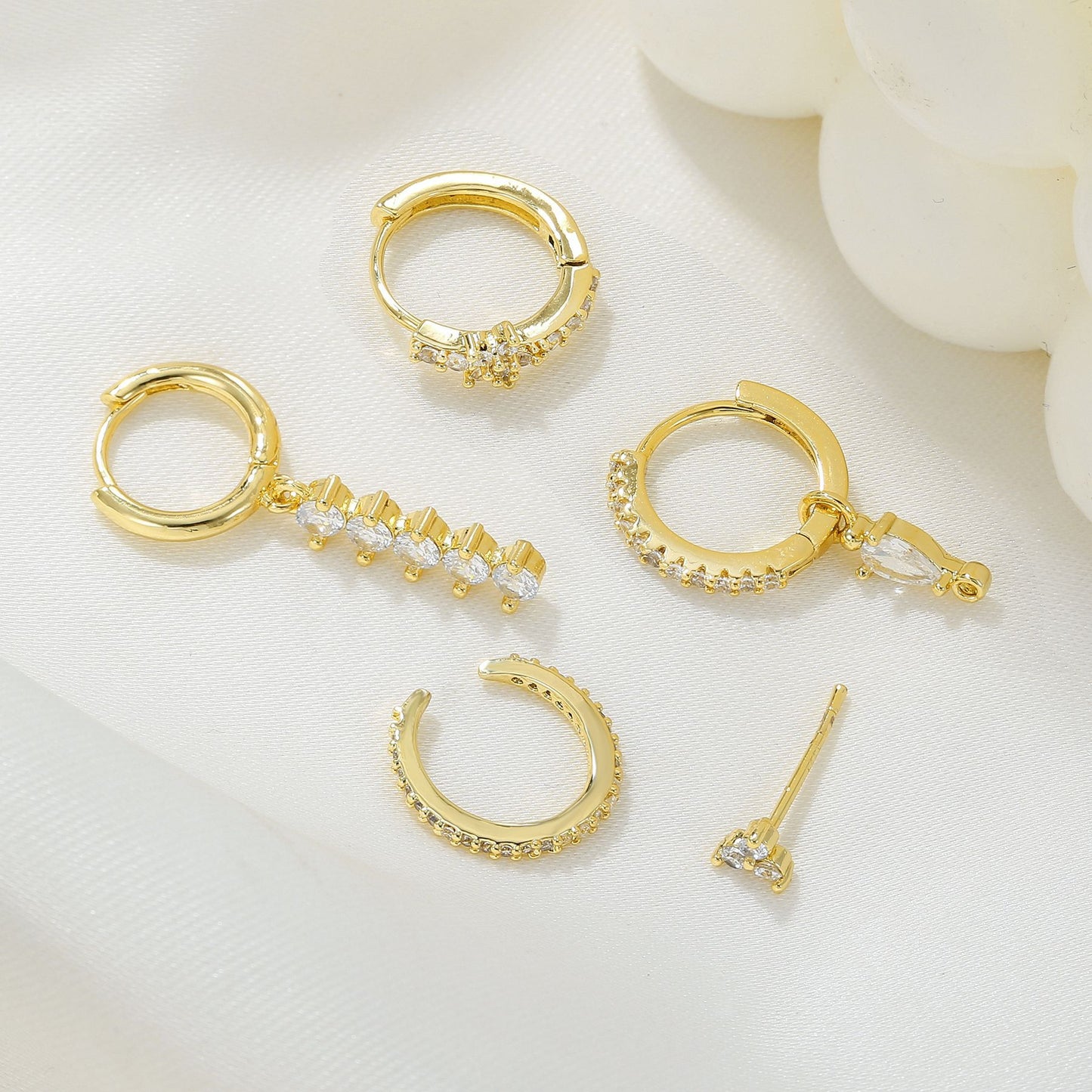 Set of gold hoop earrings on a light background