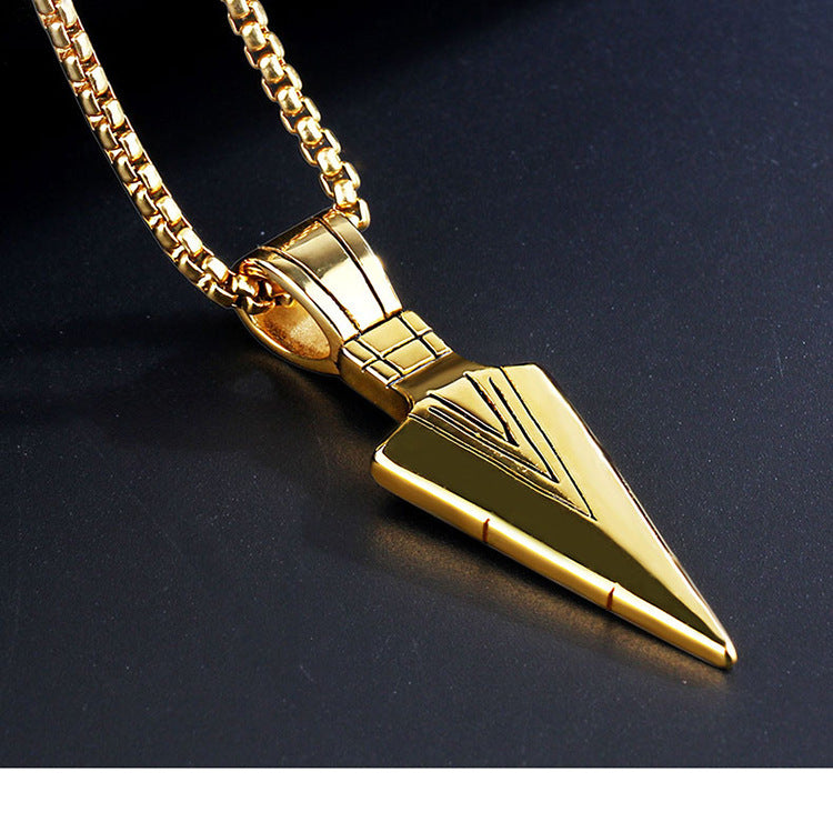 Gold spike-shaped pendant on a chain against a dark background