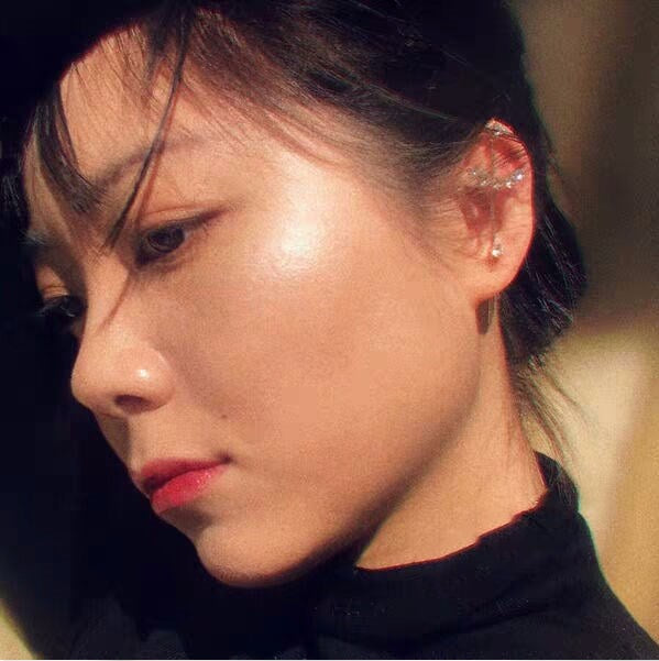 Close-up of a person wearing a black turtleneck with a blurred background