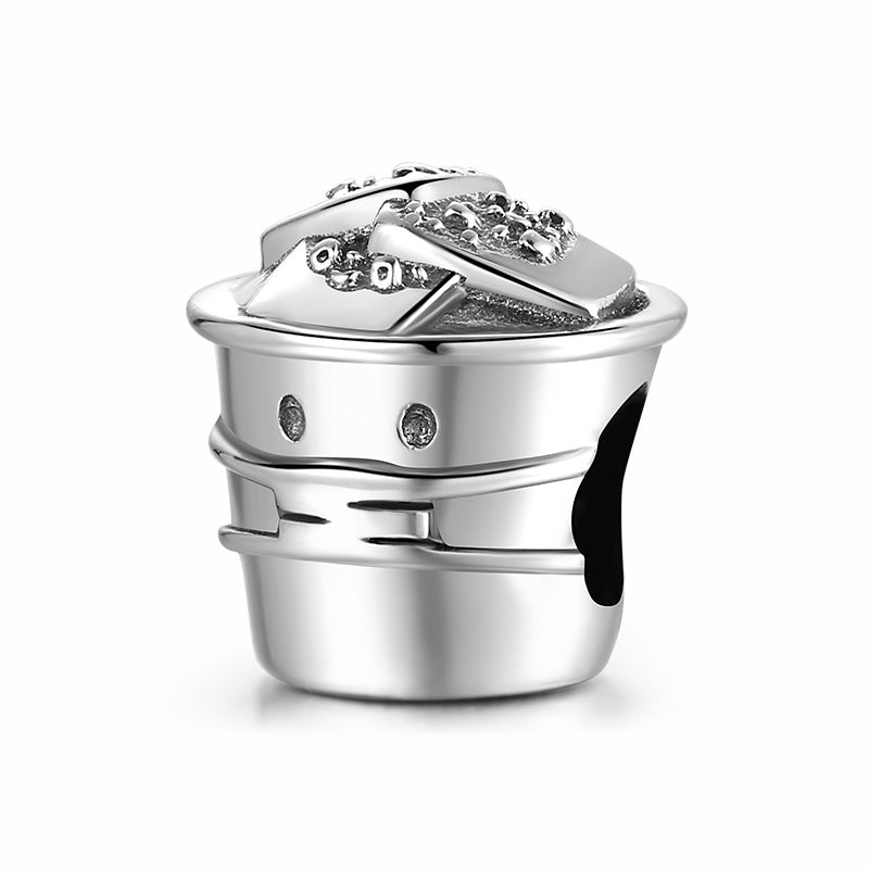 Silver charm with intricate design on a white background