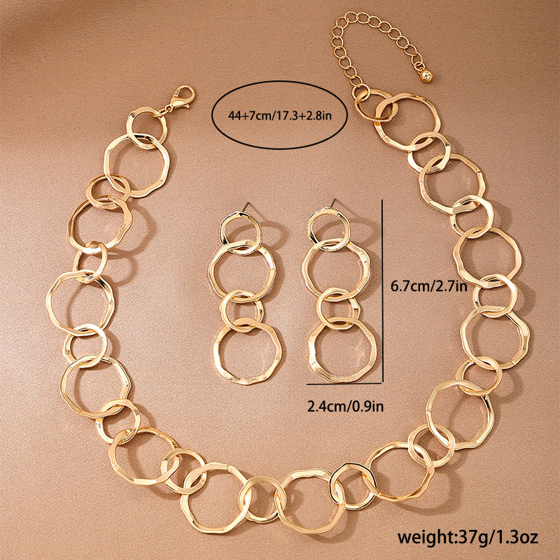 Gold chain necklace and earrings with measurements on a beige background