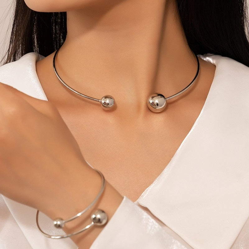Silver necklace and bracelet on a person wearing a white shirt
