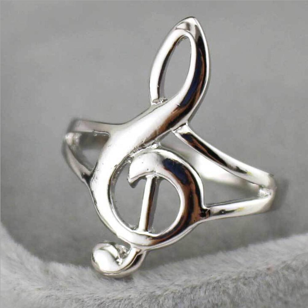 Silver treble clef ring on a gray background