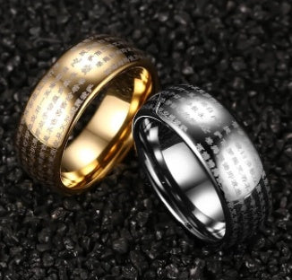 Two rings, one gold and one silver, on a textured black surface
