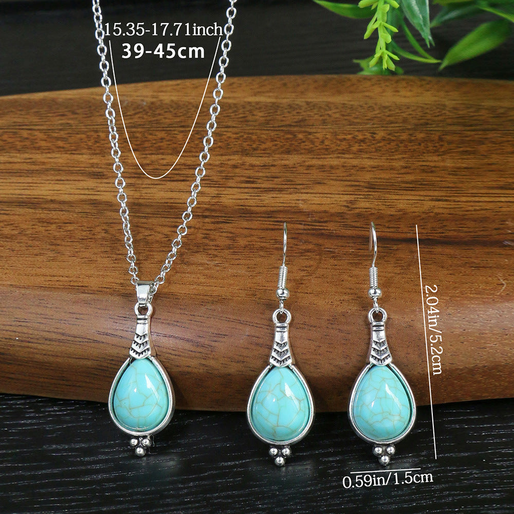 Turquoise pendant necklace and earrings on a wooden surface with measurements.