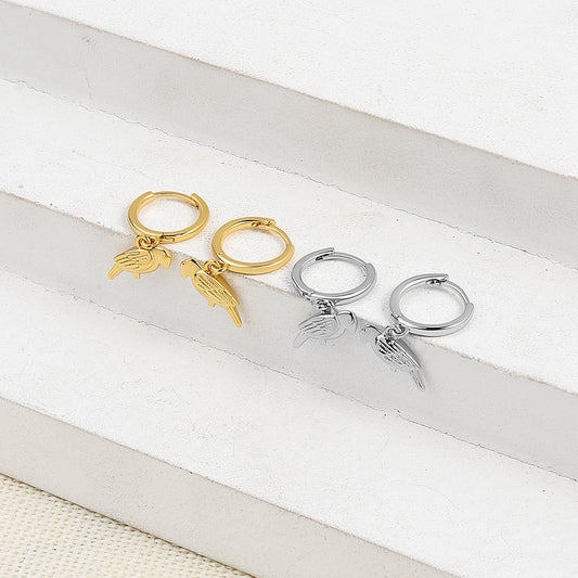 Gold and silver hoop earrings with angel wing charms on a white surface.