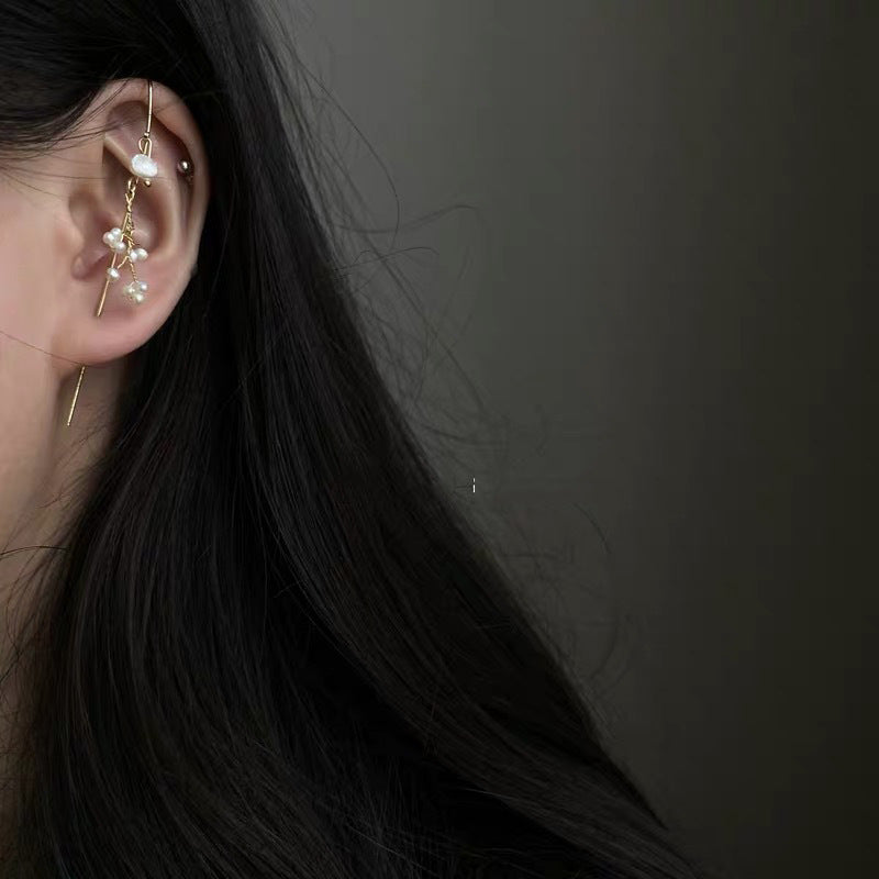 Close-up of an ear with a delicate earring against a dark background