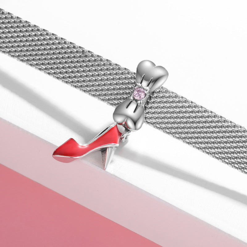 Silver bracelet with a red high-heeled shoe charm on a white and pink background