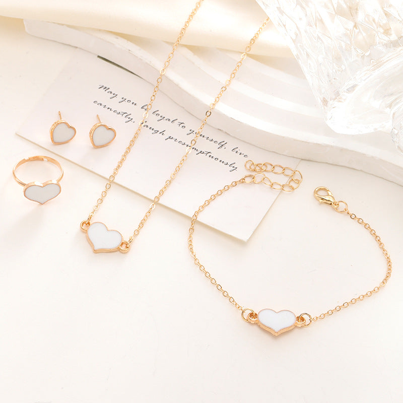Gold bracelet with heart-shaped charms on a white surface