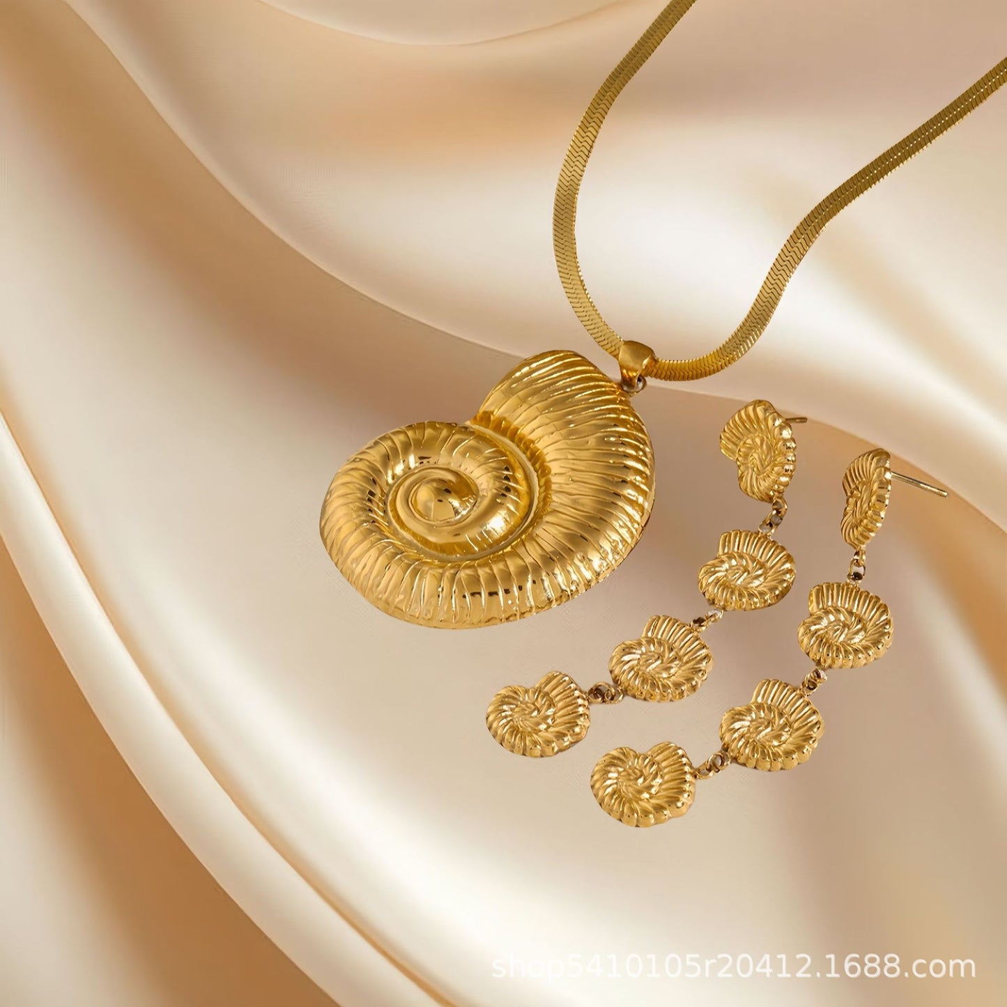 Gold necklace and earrings on a beige fabric background