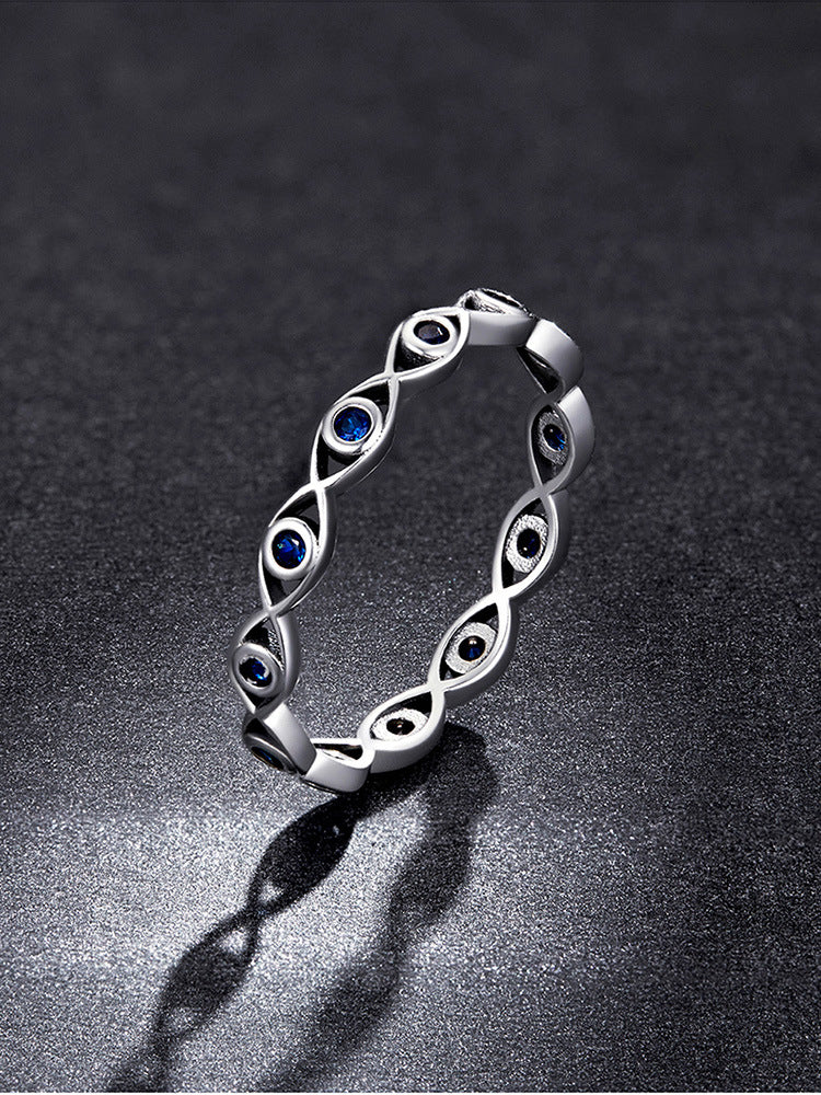 Silver bracelet with eye designs on a dark background