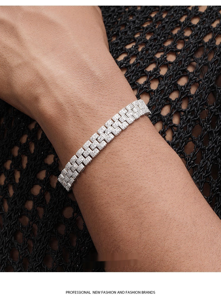 Silver bracelet on a wrist with a black textured background