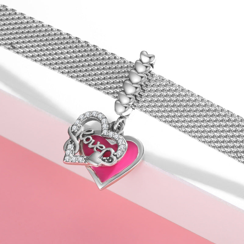 Silver bracelet with a heart-shaped charm on a pink and white background