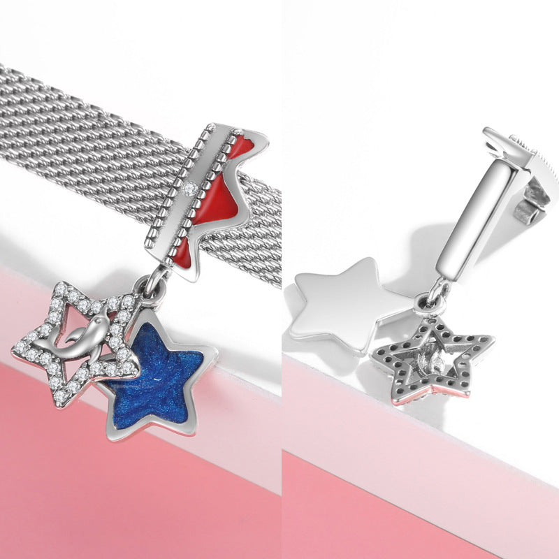 Star-shaped charm with blue glittery center on a silver chain against a pink background