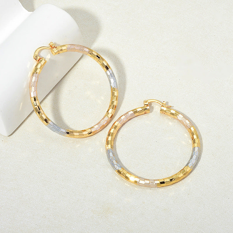 Two gold and silver hoop earrings on a light background