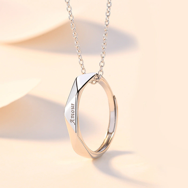 Silver ring with 'Amour' engraving on a beige background