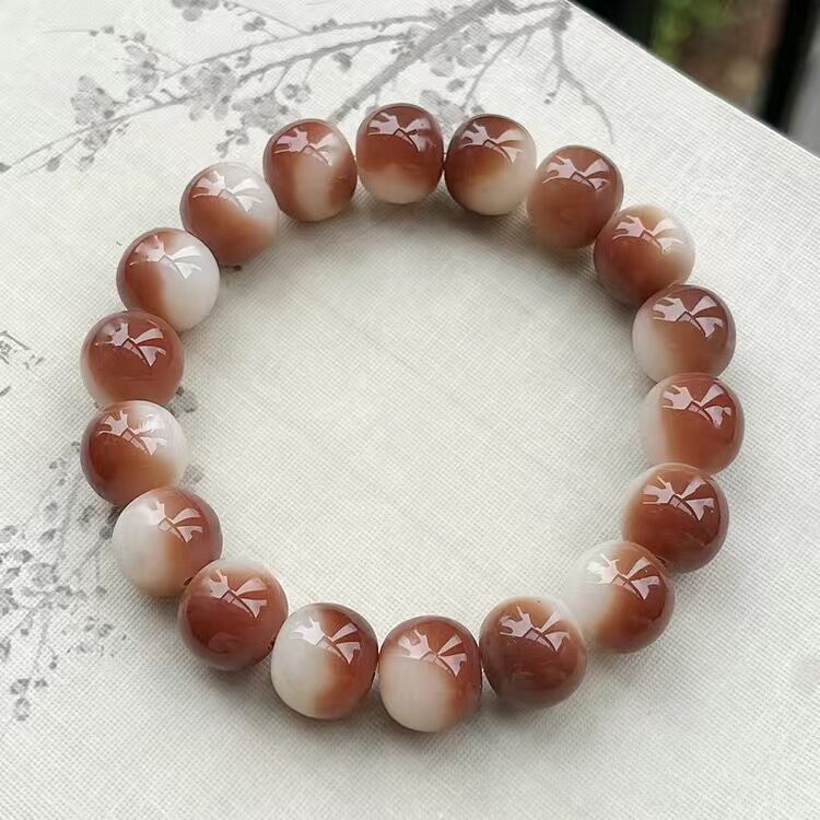 Beaded bracelet with brown and white beads on a light fabric background