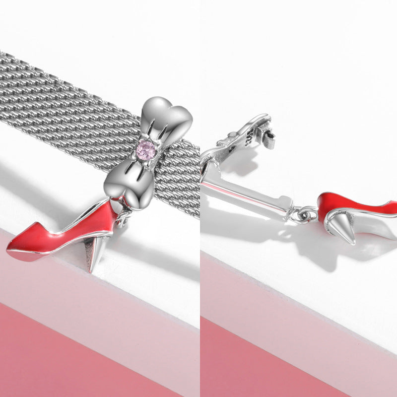 Silver high-heeled shoe charm with a pink heart on a white background