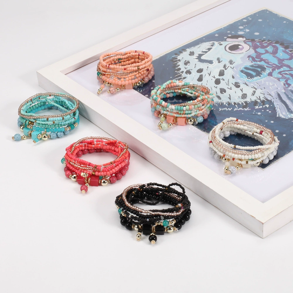 Set of colorful beaded bracelets on a white surface with a decorative box in the background.