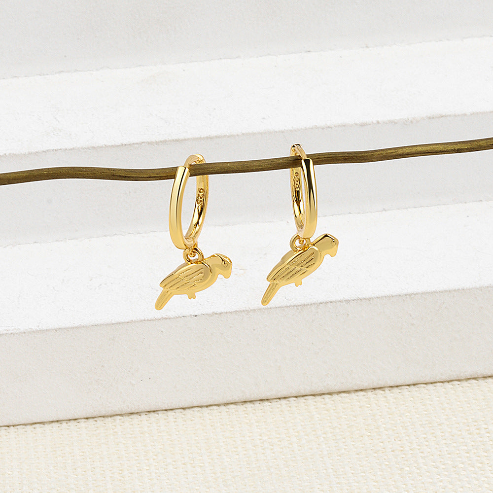 Gold hoop earrings with parrot charms on a white background