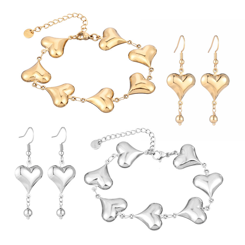 Gold and silver heart-shaped jewelry set on a white background