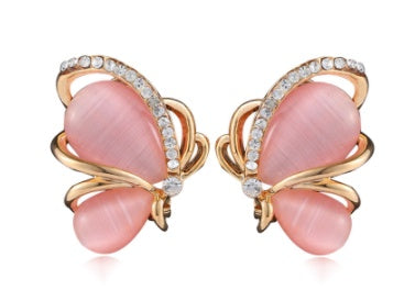 Butterfly-shaped earrings with pink stones and gold accents on a white background