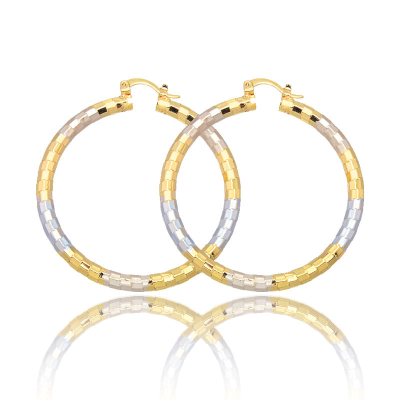 Pair of gold and silver hoop earrings on a white background