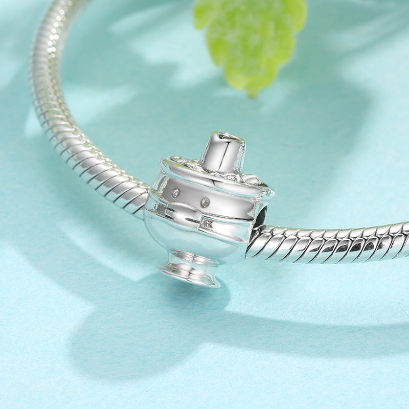 Silver bracelet charm on a light blue background