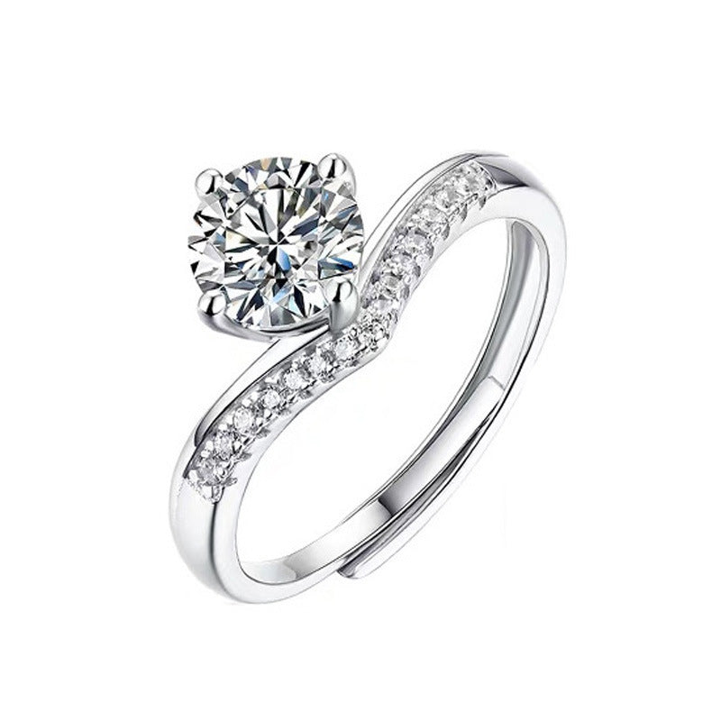 Silver ring with a large diamond and smaller diamonds on the band against a white background