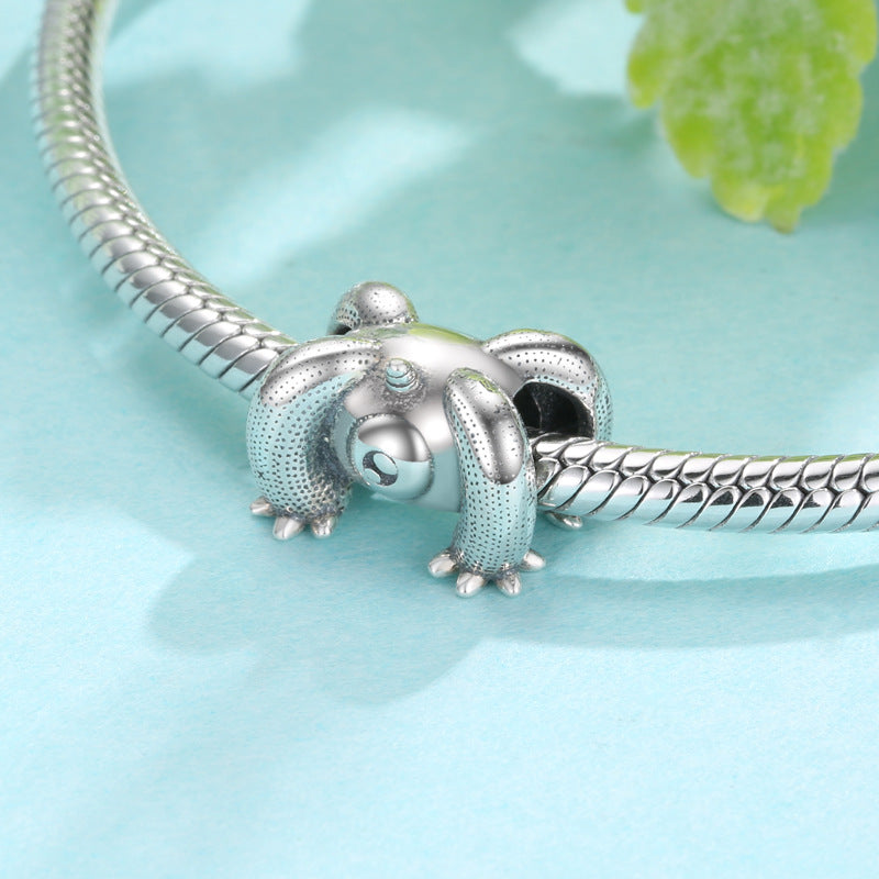 Silver turtle charm on a snake chain against a light blue background