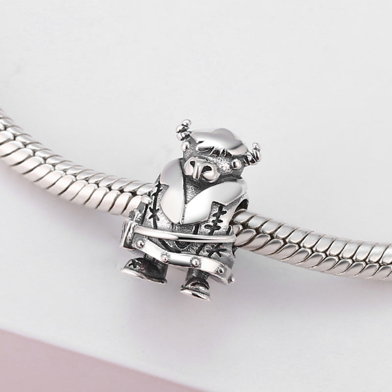 Silver owl charm on a snake chain against a light pink background