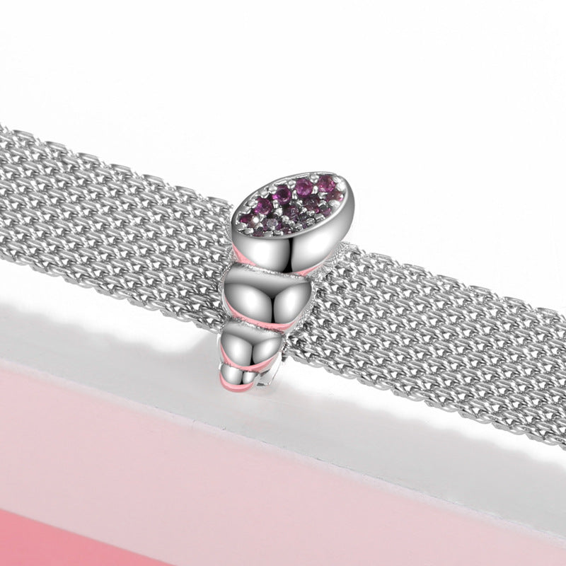 Silver chain bracelet with a decorative clasp on a pink surface