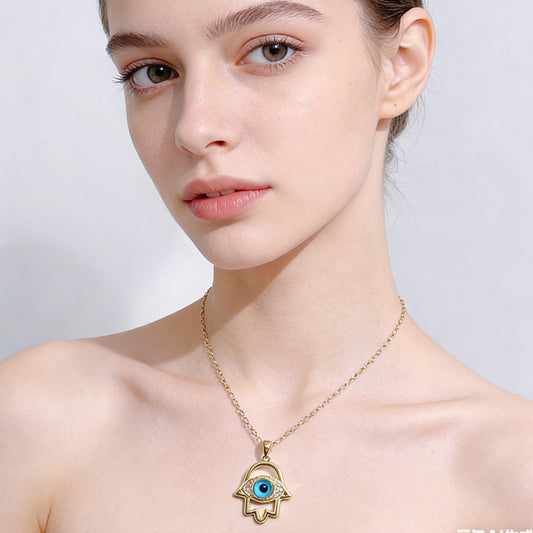 Woman wearing a gold necklace with an eye-shaped pendant on a plain background