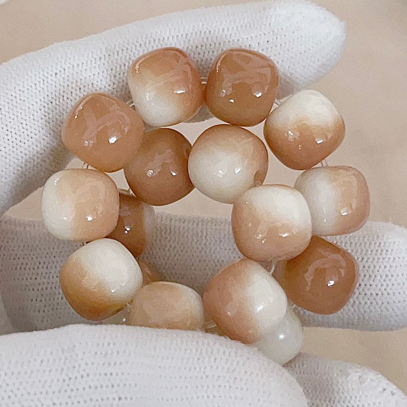 Necklace with beige and white beaded bracelet on a textured surface