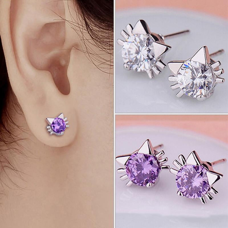 Cat ear stud earrings with purple gemstones worn on an ear, shown from multiple angles.