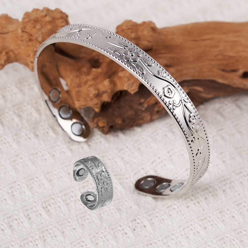 Silver bracelet with intricate designs on a textured surface