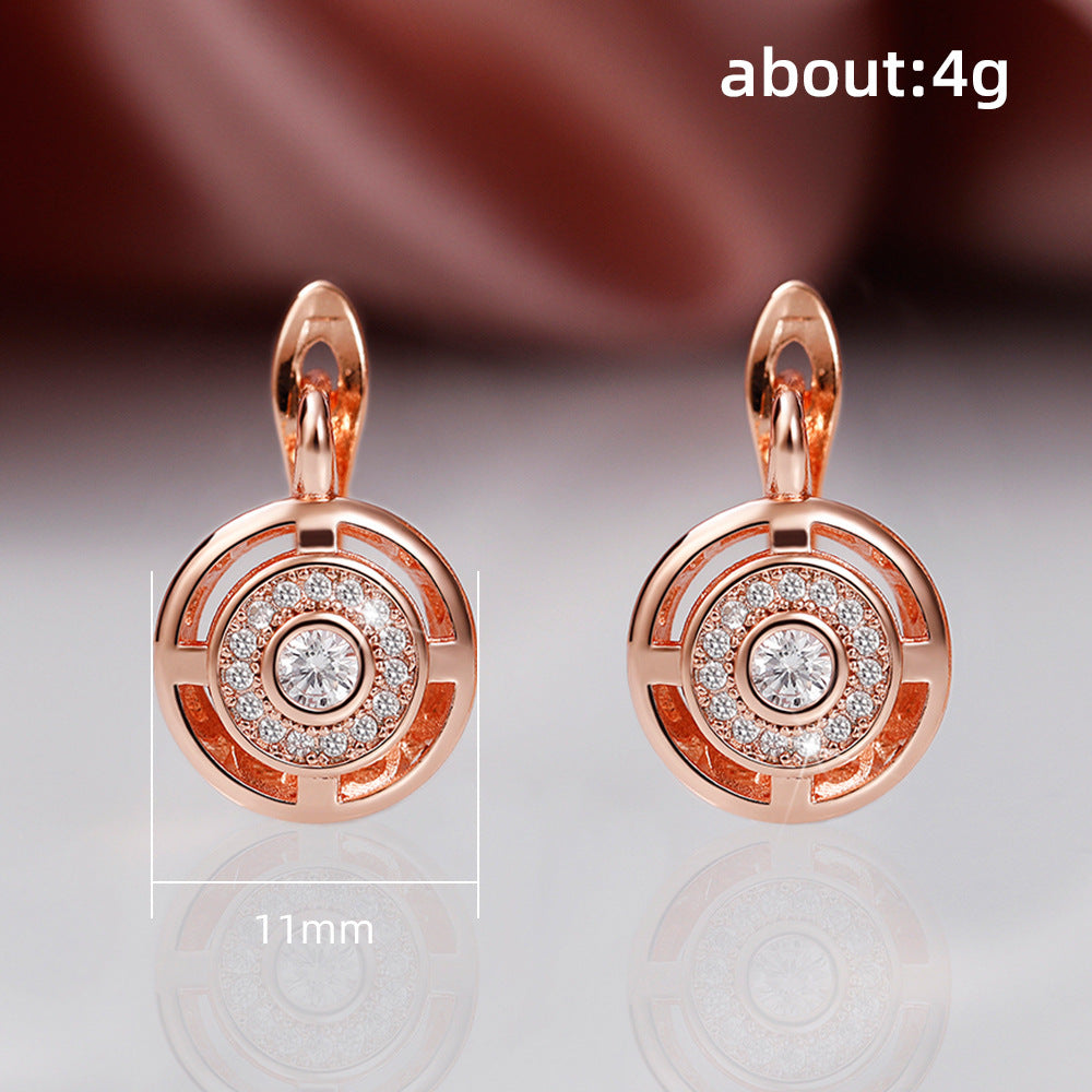 Rose gold earrings with gemstones on a reflective surface, labeled 'about:4g'.