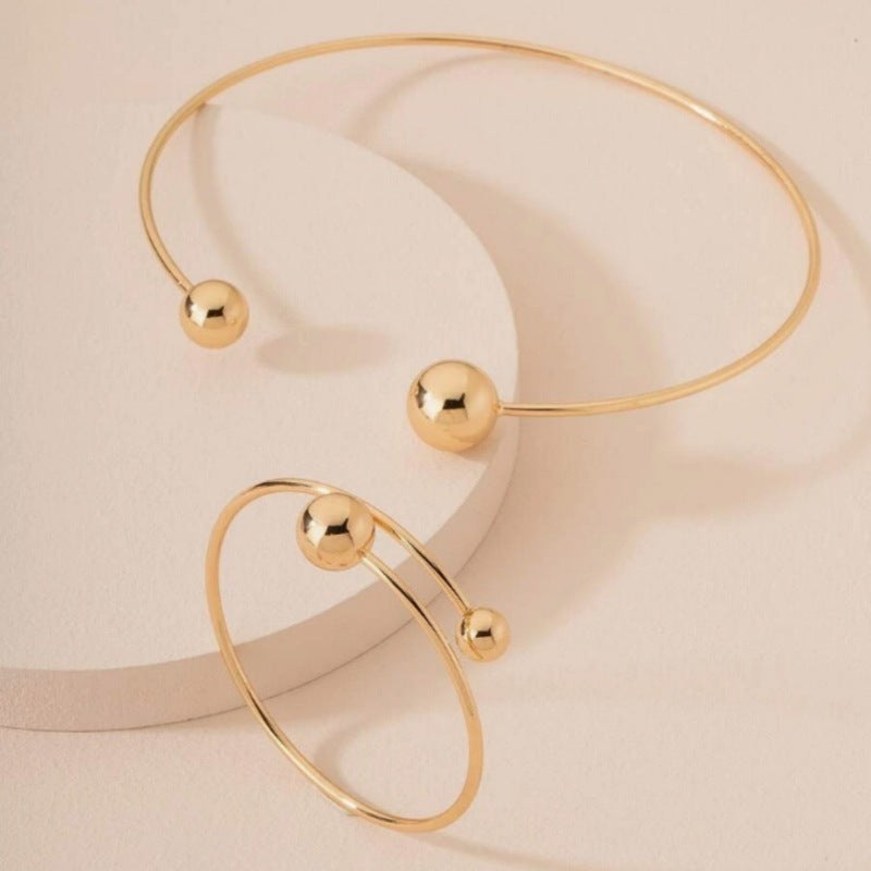 Gold bracelet with spherical beads on a beige background