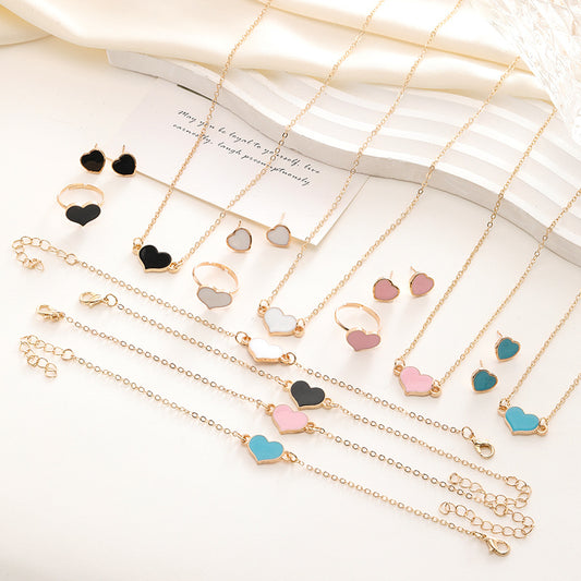 Collection of gold necklaces with heart-shaped charms on a white surface.