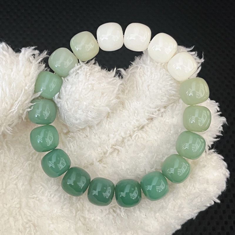 Green beaded bracelet on a textured white surface