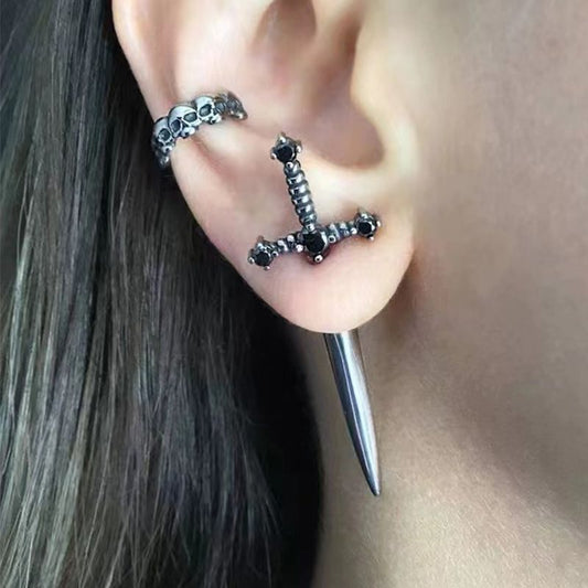 Close-up of an ear with a unique earring featuring a sword design.