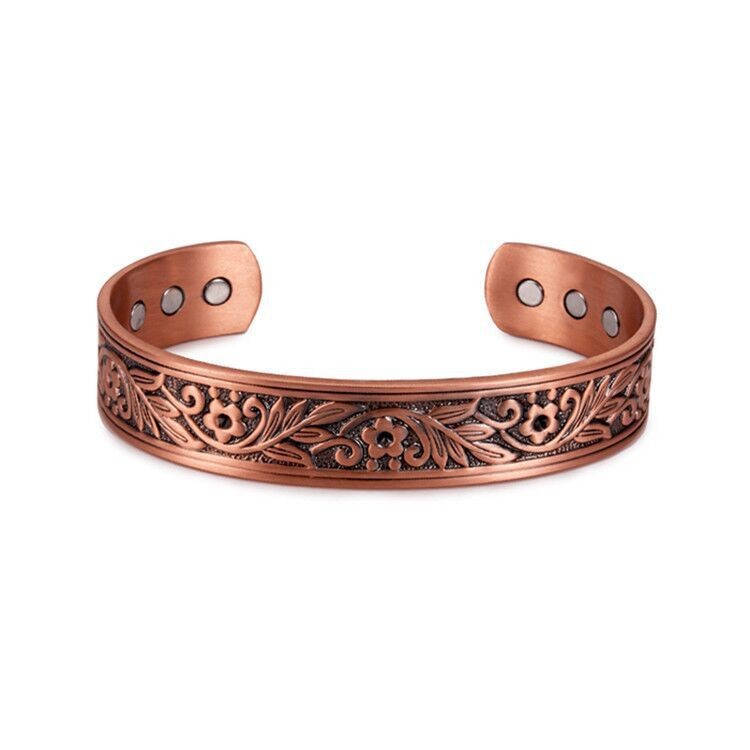 Copper bracelet with intricate designs on a white background